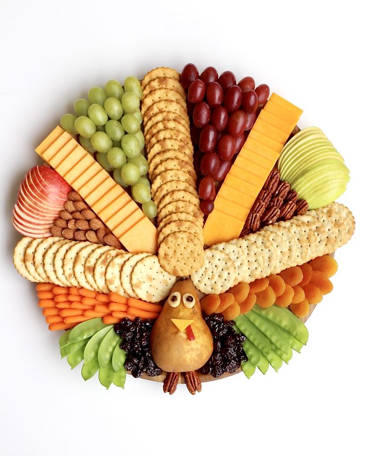 a turkey shaped platter filled with cheese, crackers, grapes, and nuts