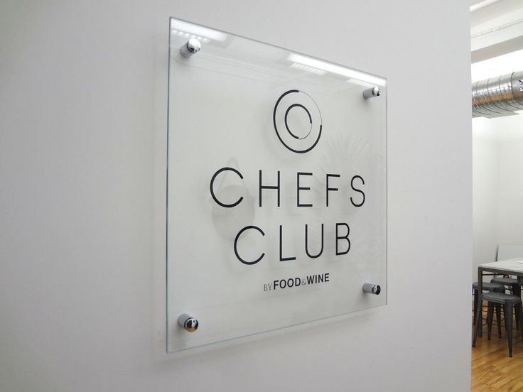 a glass sign that says chefs club on the side of a wall in a restaurant