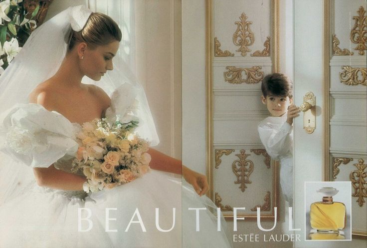 a woman in a wedding dress standing next to a little boy