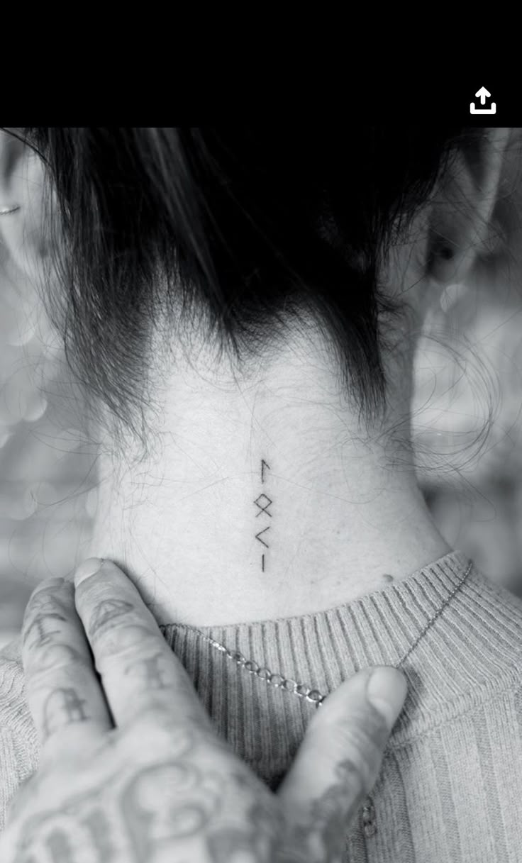 a woman's neck with a small tattoo on her left side ribcage