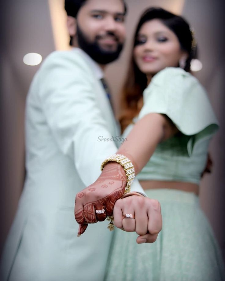 a man and woman holding hands in front of each other