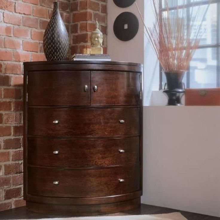 a wooden dresser sitting next to a brick wall