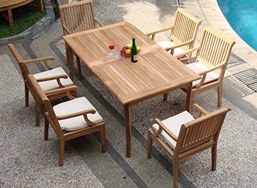 an outdoor table and chairs next to a pool with a bottle of wine on it