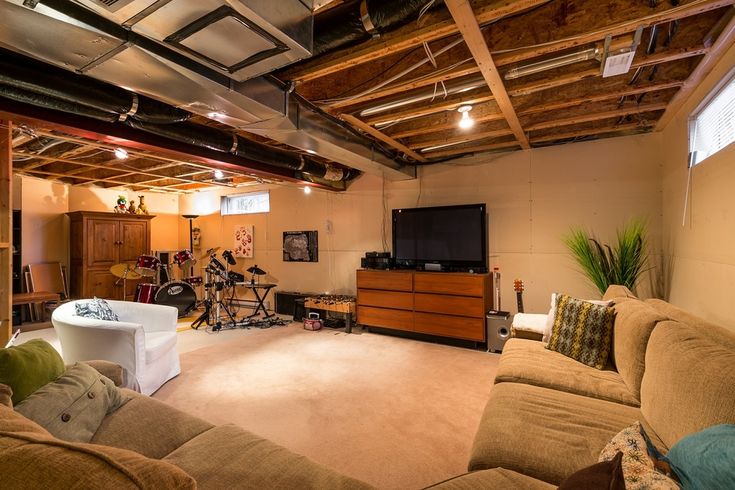 a living room filled with furniture and a flat screen tv mounted to the wall above it