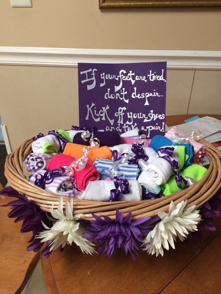 a basket filled with lots of colorful items on top of a wooden table next to a sign