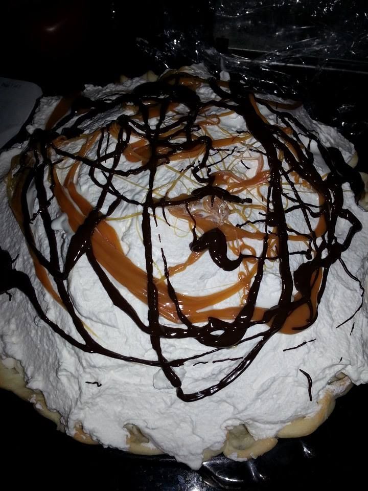 a cake covered in white and brown icing on top of a black countertop