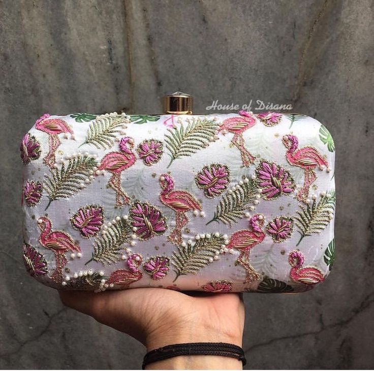 This is a beautiful flamingo handwork clutch bag.It's stylish design makes it perfect for everyday wear.It comes with a metal sling chain. Details  - Single side handwork  - Fabric lining on the inside to keep your belongings safe  - Metal lock closure  - Diamond studded knob - Detachable sling chain  This clutch can be worn as a crossbody bag or a shoulder bag with the sling chain or can simply be carried in hand.It is spacious enough to carry mobile phones, lipsticks, Keys and other small acce Designer Rectangular Pouch As Gift, Trendy Handheld Evening Bag As Gift, White Box Bag As Gift, Rectangular Floral Embroidery Pouch, Designer Embroidered Rectangular Bag, Elegant Summer Box Bag Tote Shape, Elegant Summer Tote Box Bag, Pink Rectangular Shoulder Bag With Handwork, Elegant Rectangular Box Bag For Summer