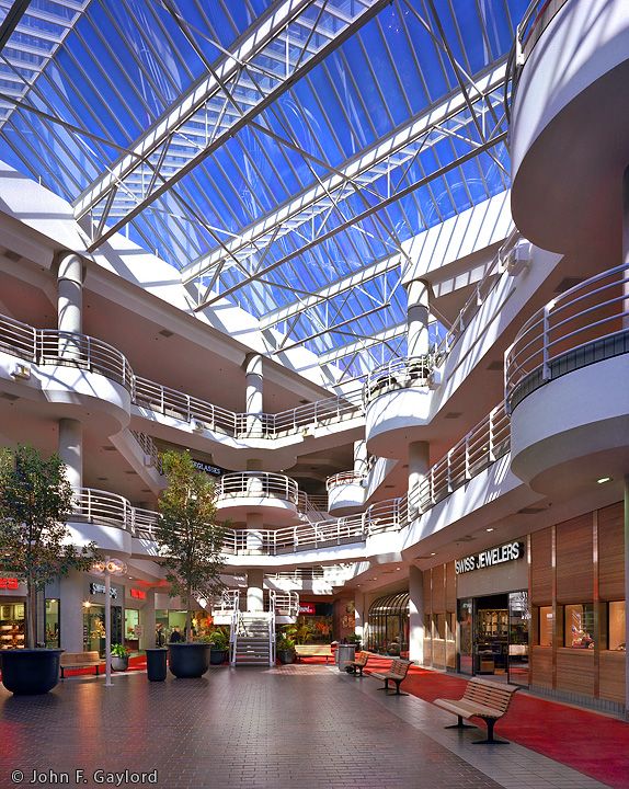 the inside of a shopping mall with glass ceiling