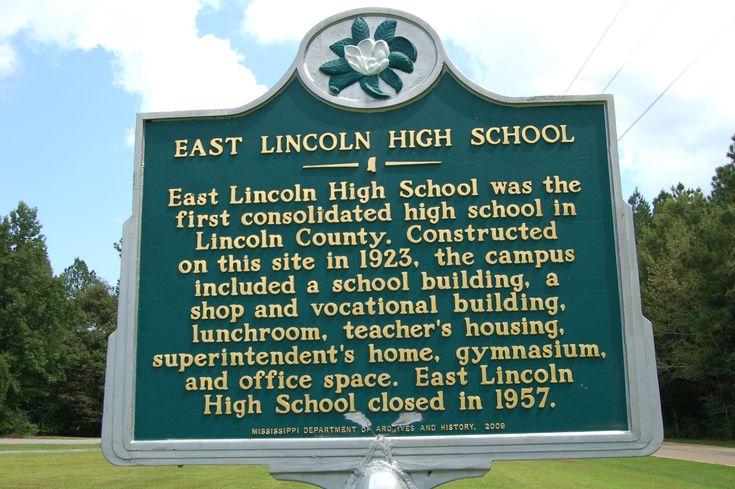 a sign in front of some trees that says east lincoln high school and the first lincoln high school