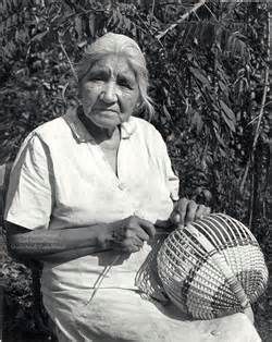 an old woman sitting on a bench holding a basket