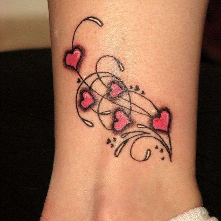 a woman's foot with hearts and swirls on the side, tattoo style