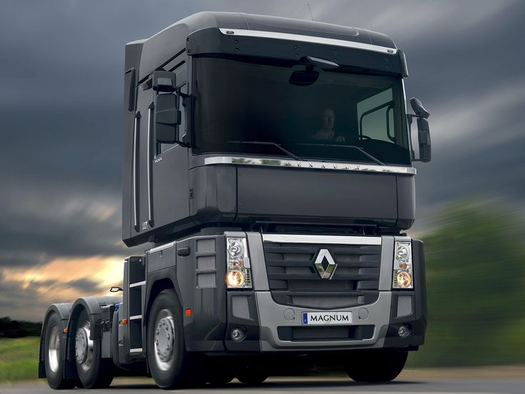 a black truck driving down a road under a cloudy sky with dark clouds in the background