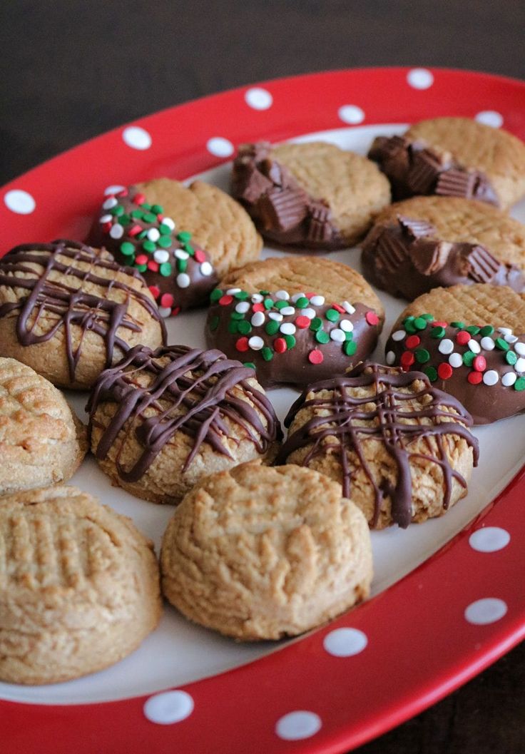 a red plate topped with cookies covered in frosting and sprinkles on top of a table