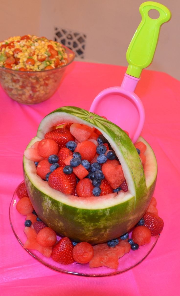 there is a watermelon cut in half with strawberries and blueberries on it