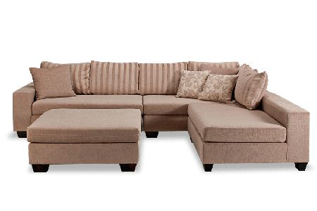 a large sectional couch with pillows on the back and footrests, in front of a white background