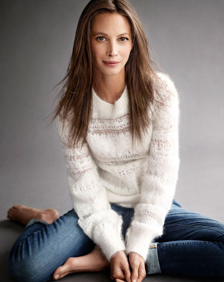 a woman is sitting on the floor with her legs crossed and looking at the camera