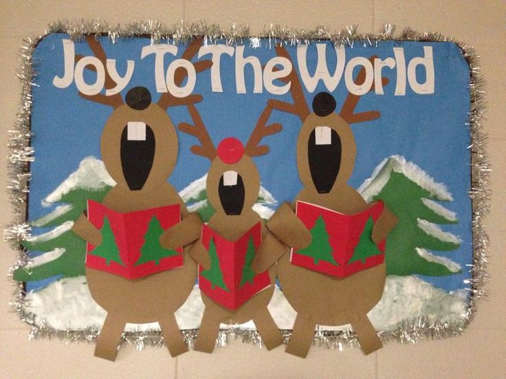 a bulletin board with two reindeers holding presents in front of the words joy to the world