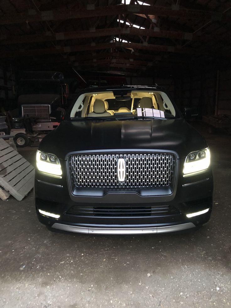 the front end of a black car in a garage