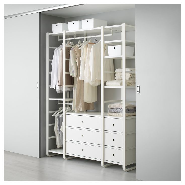 a white closet with drawers and clothes on it