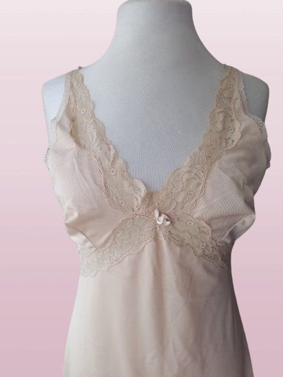 Vintage 70s lingerie, beige under dress , retro lace , slip dress S-M ,newer worn Bust: 92 cm / 36 in Waist: 80 cm/ 31 in Hips: 110 cm/ 43 in Lenght:  100 cm/ 39 in Size : S-M Materials: 100% nylon Condition: perfect vintage condition Defects: none See more like this in my shop: https://www.etsy.com/shop/VintageInsparation?ref=seller-platform-mcnav ---------------------------- Be welcome to visit my other Etsy shop for handmade upcycled clothes and bags: https://www.etsy.com/shop/ArtAnnByBoutiqu Lace Slip Dress With Built-in Bra For Daywear, Feminine Camisole Slip Dress With Delicate Lace, Feminine Sleeveless Slip Dress With Lace Bodice, Sheer Camisole Slip Dress For Daywear, Feminine Cream Slip Dress With Spaghetti Straps, Lace Camisole Slip Dress With Lace Bodice, Sleeveless Lace Slip Dress With Built-in Bra, Coquette Lace Trim Slip Dress For Daywear, Flirty Lace Trim Slip Dress For Daywear