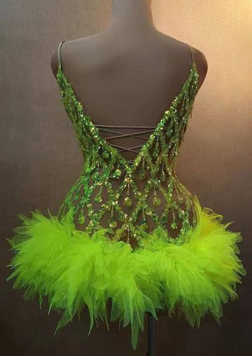 a mannequin wearing a green dress with feathers on it's chest and back