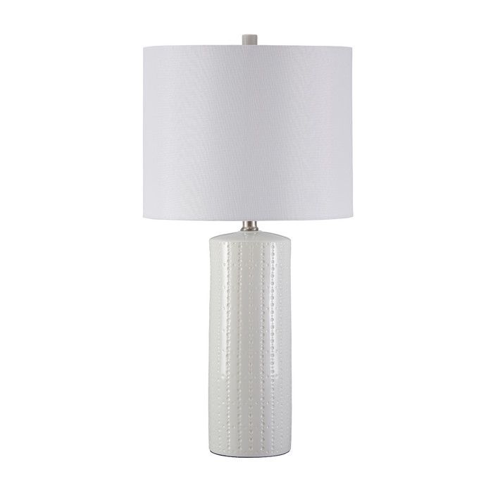 a white table lamp with a white shade on the base and a white drum light