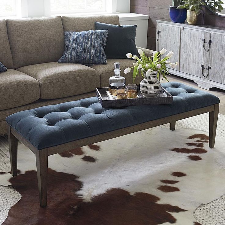 a living room with a couch, coffee table and cow hide rug on the floor