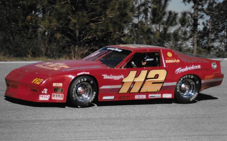 a red race car driving around a track