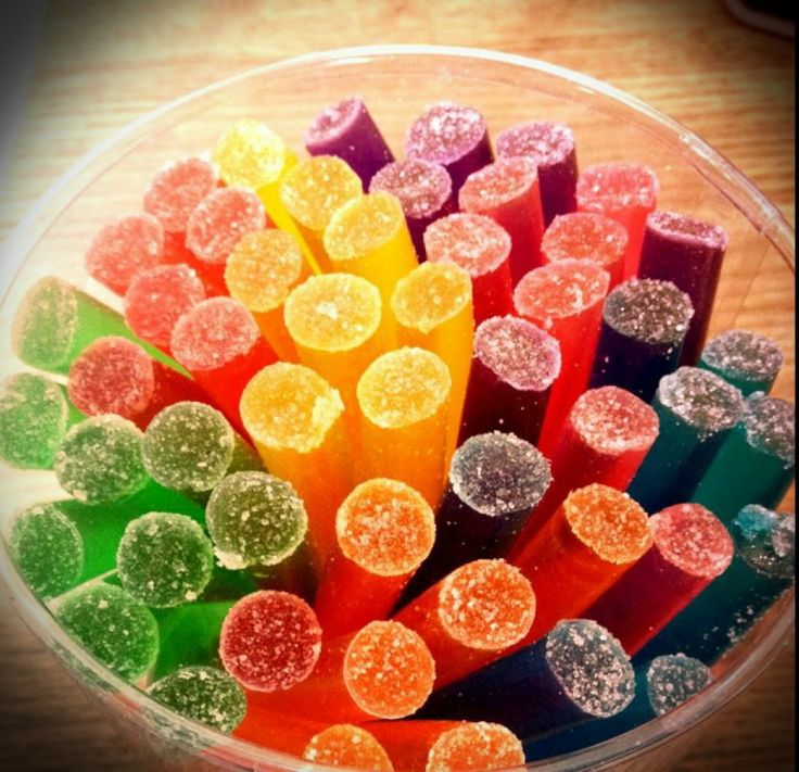 there are many different colored candy sticks in the bowl