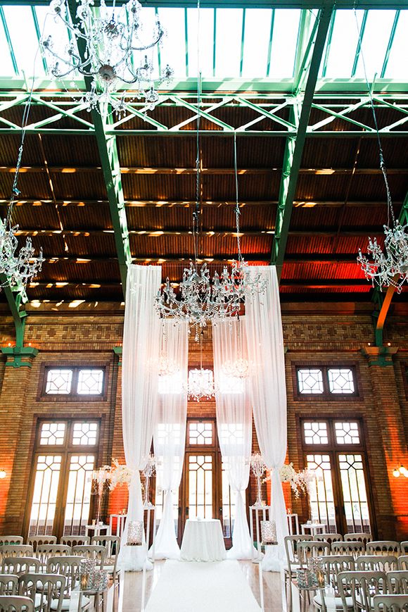 an indoor wedding venue with chandeliers and chairs