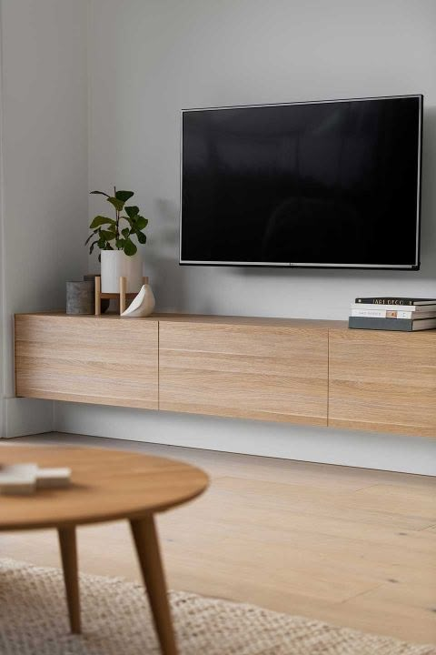 a flat screen tv sitting on top of a wooden entertainment center in a living room