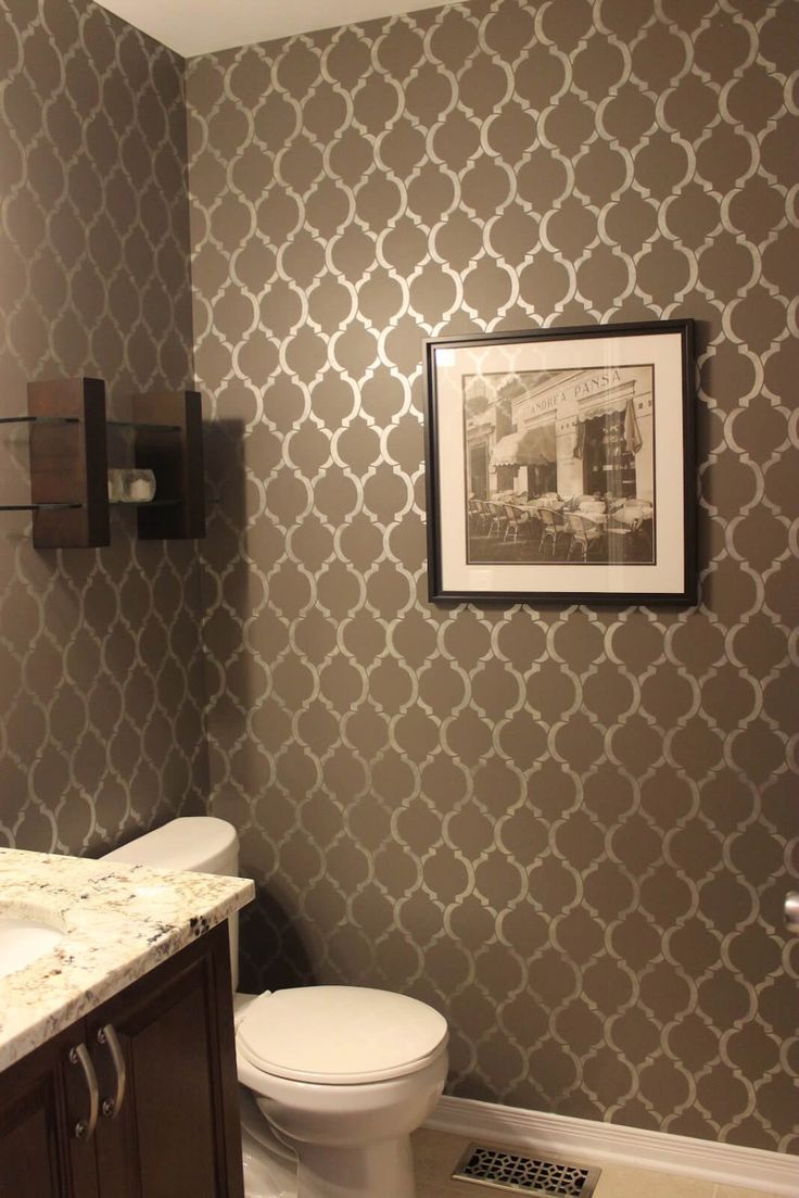 a white toilet sitting next to a bathroom sink under a framed picture on the wall