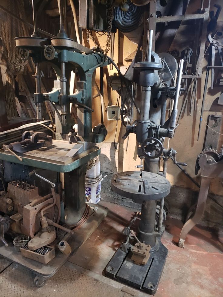 an old machine is sitting in the middle of a room filled with tools and equipment