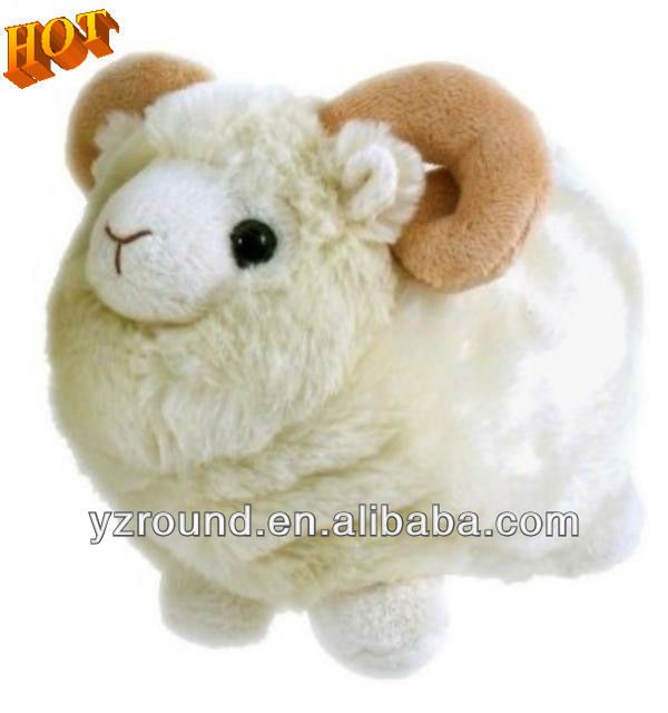 a stuffed sheep is laying down on the floor with it's head turned to the side