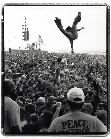 a man doing a handstand in front of a large crowd at a concert