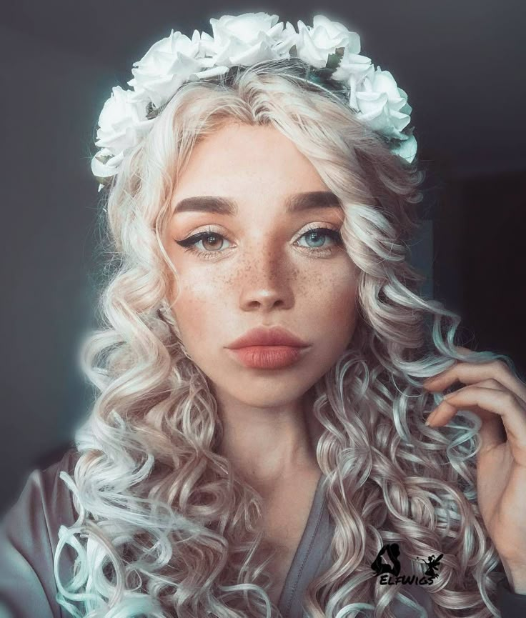 a woman with freckles and flowers on her head is looking at the camera