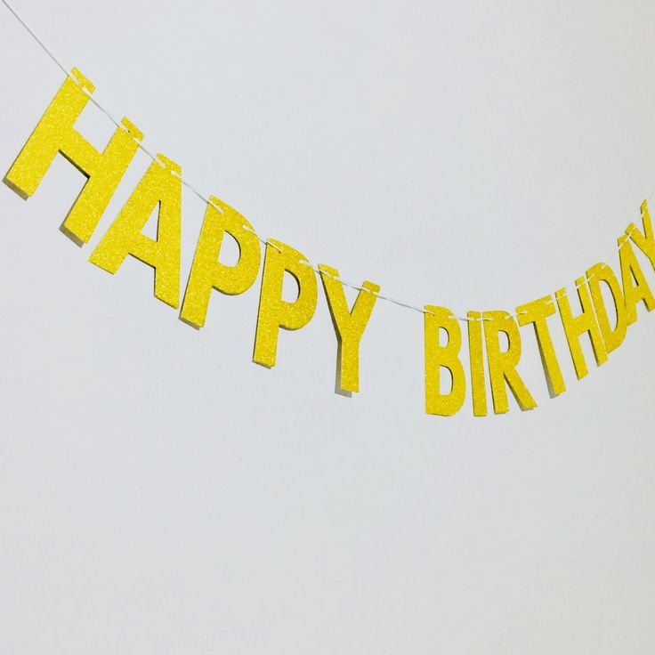 a yellow happy birthday banner hanging from a string