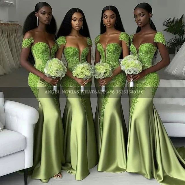 three women in green dresses standing next to each other and one is holding a bouquet