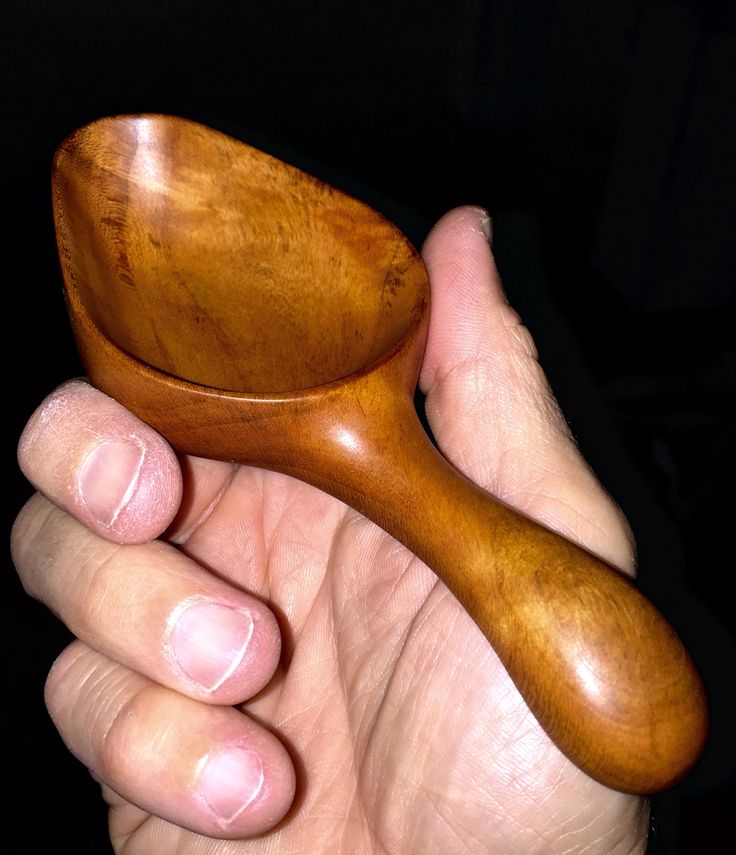 a person holding a wooden spoon in their hand