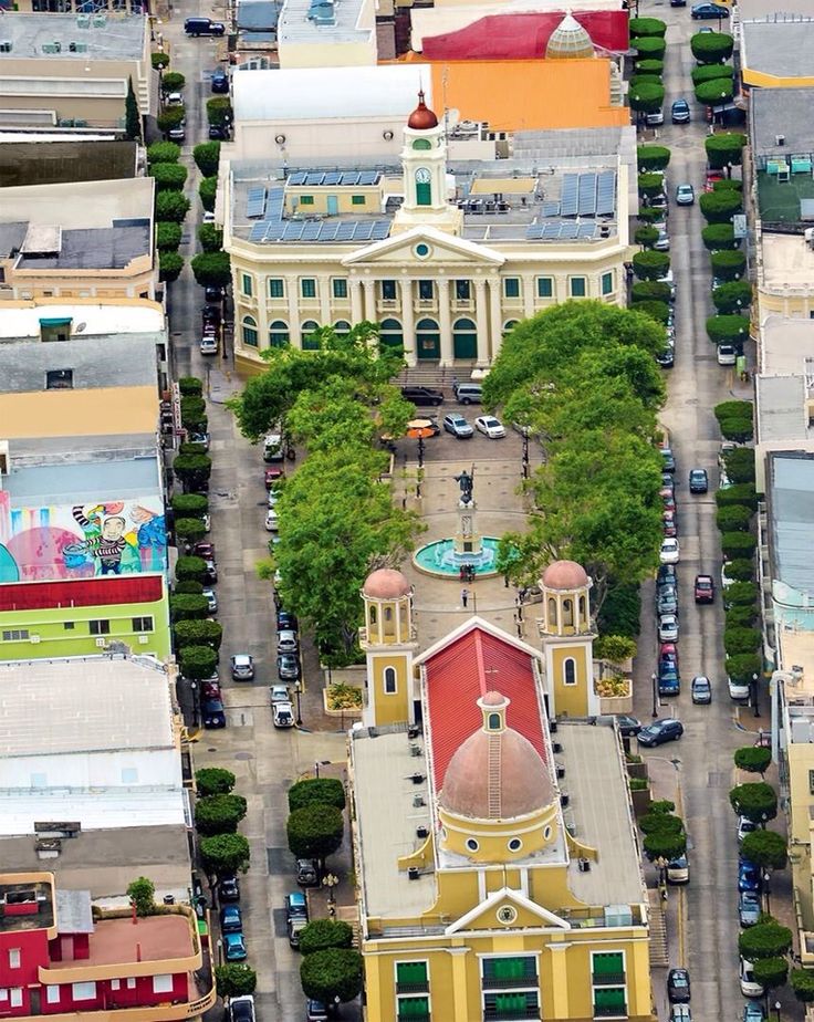 an aerial view of a city with lots of buildings and cars parked on the street