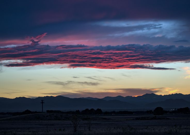 the sun is setting over mountains in the distance