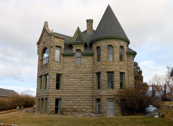 an old brick building with two towers on the top and one at the bottom, in front of a cloudy sky