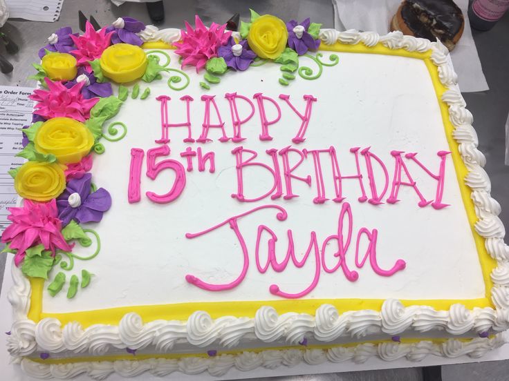 a white and yellow birthday cake with flowers on it