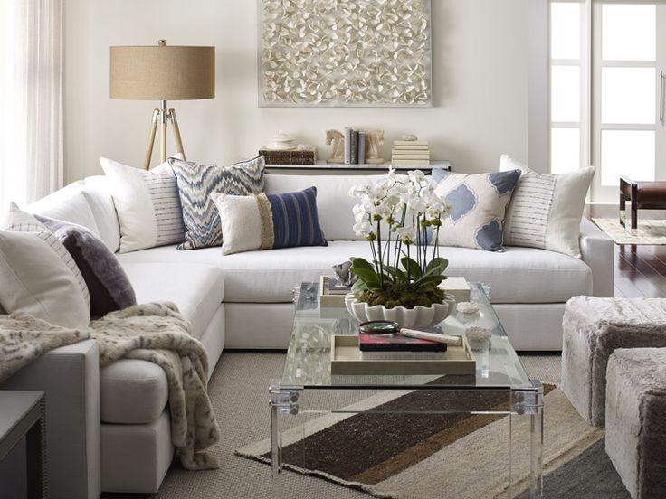 a living room filled with furniture and a painting on the wall above it's coffee table