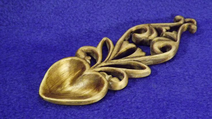 an ornate brass drawer pull handle on a blue background