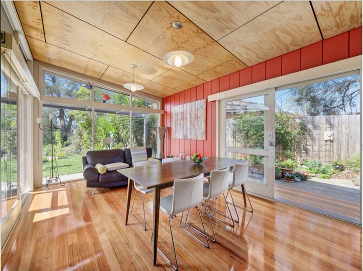 a dining room with wood floors and red walls