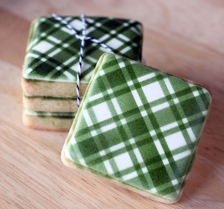 three green and white plaid cookies on a wooden table