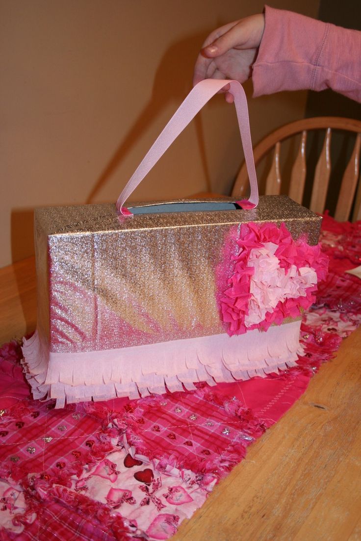 a pink and gold gift bag sitting on top of a table