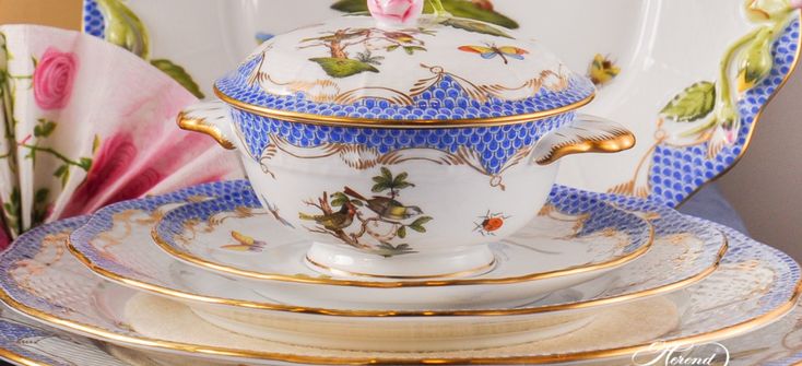 an ornately decorated china tea set with pink flowers on the top and gold trimmings