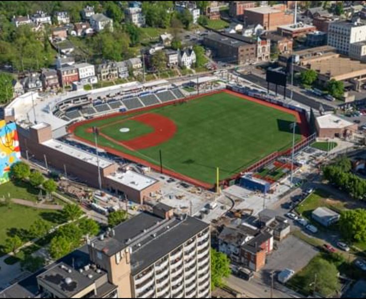 an aerial view of a baseball field in the middle of a city with buildings around it